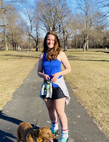 Reviewer wearing mint inline skates while walking dog