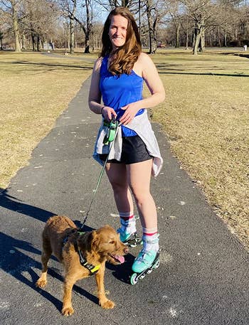 Reviewer wearing mint inline skates while walking dog