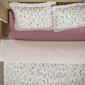 Floral and striped bedding acceptable   with ruffled pillowcases connected  a bed