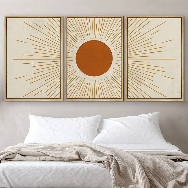 an orange and white sun ray art print with continuity across three canvases
