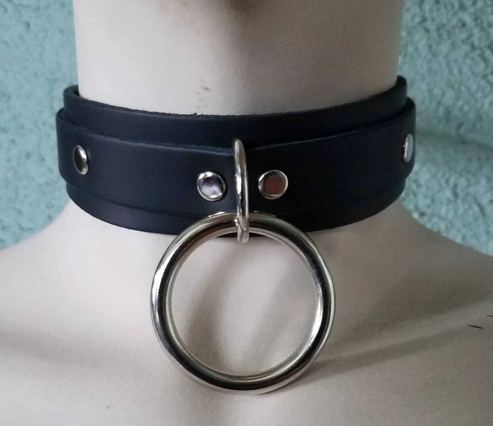 Mannequin wearing black leather collar with silvertone O-ring