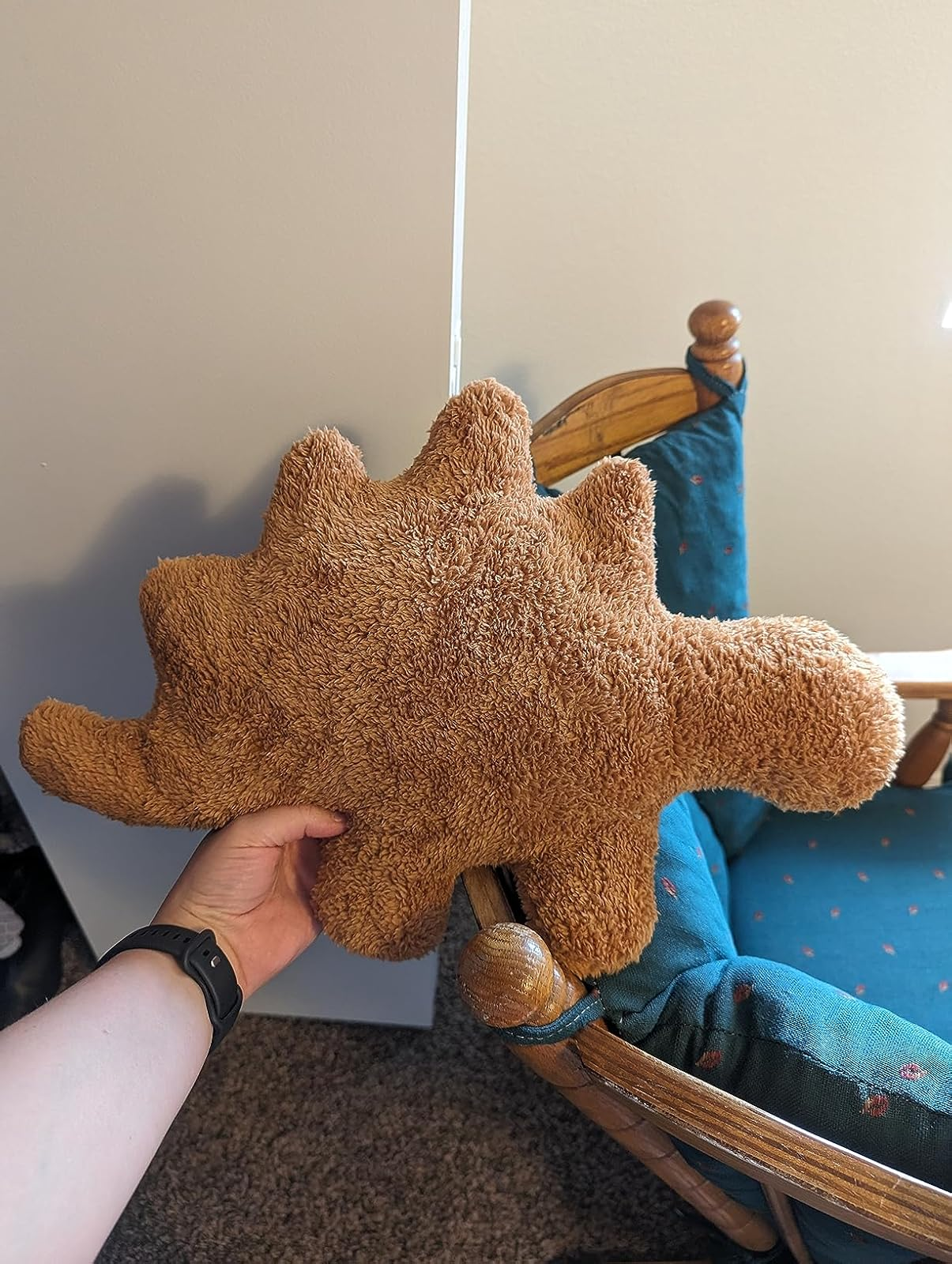 Person holding a stegosaurus nugget plush