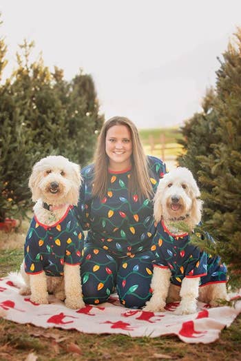 a reviewer and her two dogs in matching blue pajamas with holiday lights on them