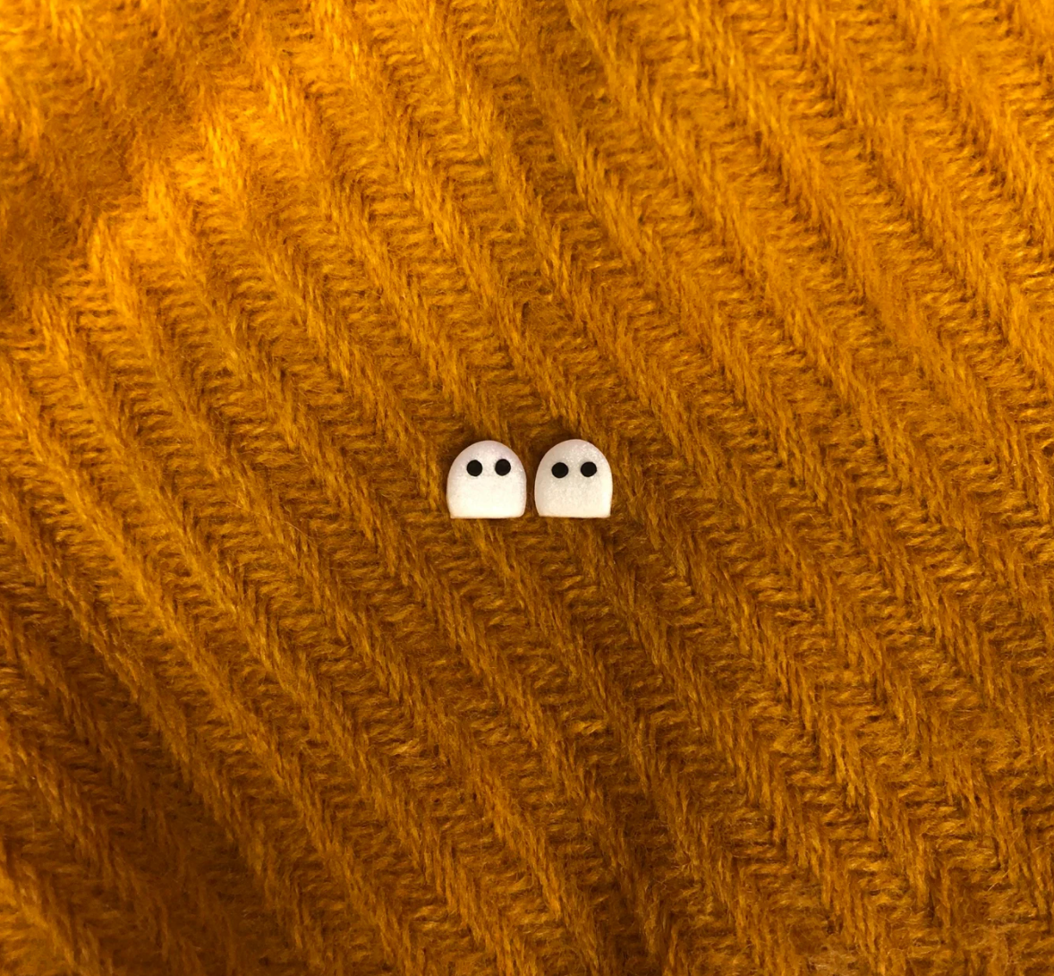 Two really tiny white ghost stud earrings