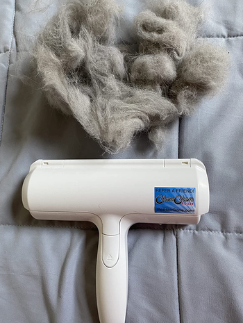 reviewer photo of the pet hair roller next to a clump of pet fur