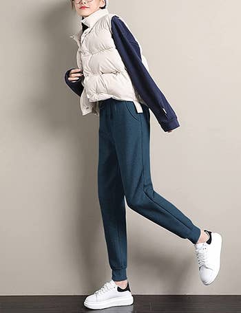 model wearing the navy joggers with a long-sleeve, tech vest, and tennis shoes