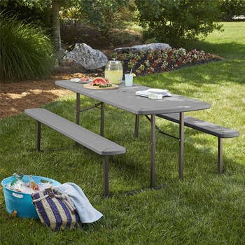lifestyle photo of gray picnic table in a backyard