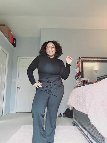 reviewer wearing black body suit with high waisted pants