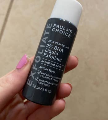 a reviewer holding the travel size 1-oz bottle