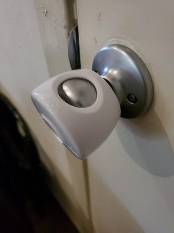 reviewer's photo of ther door knob fitted with a cover