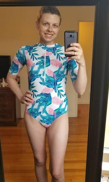 a reviewer wearing the long sleeve swimsuit featuring a blue palm print 