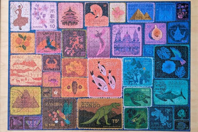 A completed puzzle depicting stamps with assorted planetary motifs, including animals, landscapes, and taste symbols