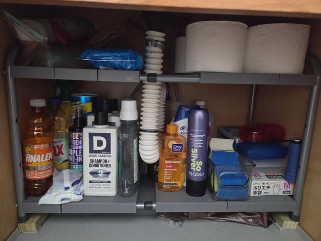 Organized furniture  with cleaning supplies, toiletries, and household   essentials neatly arranged connected  a multi-level shelf