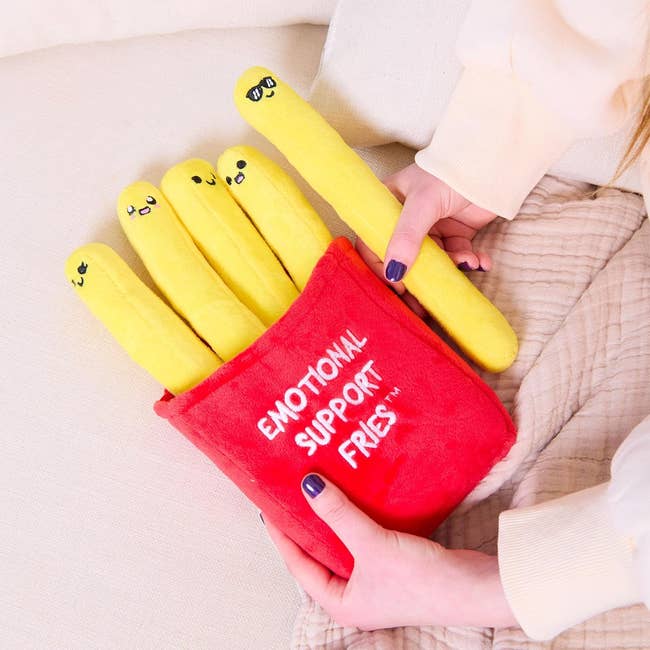 Plush toy resembling fries in a red holder with