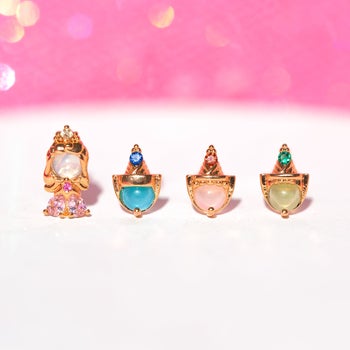 four stud earrings depicting princess aurora and her three fairy godmothers