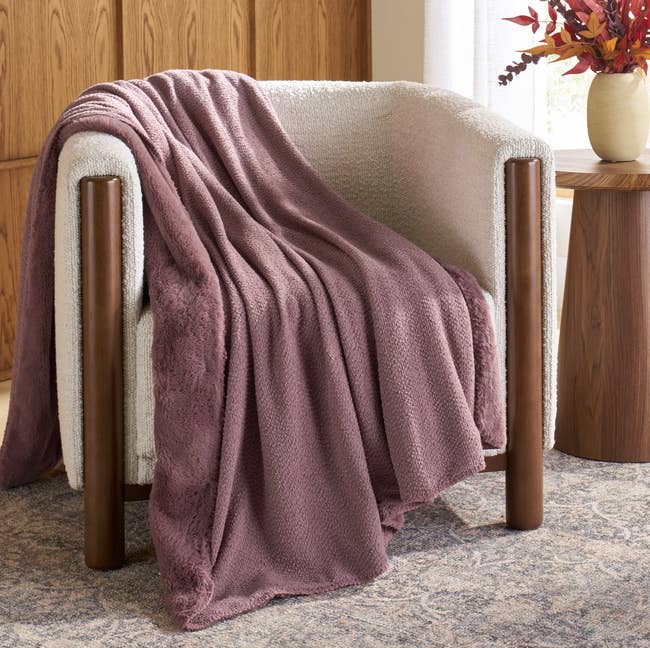 Plush textured broad draped implicit a modern armchair successful a cozy country mounting with a broadside array and vase of autumn foliage