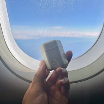hand holding a capsule on a plane