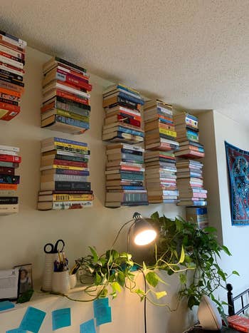multiple stacks of books mounted on a reviewer's wall using the floating bookshelves