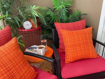 close up of reviewer's red and orange pillow covers used on outdoor pillows with patio furniture