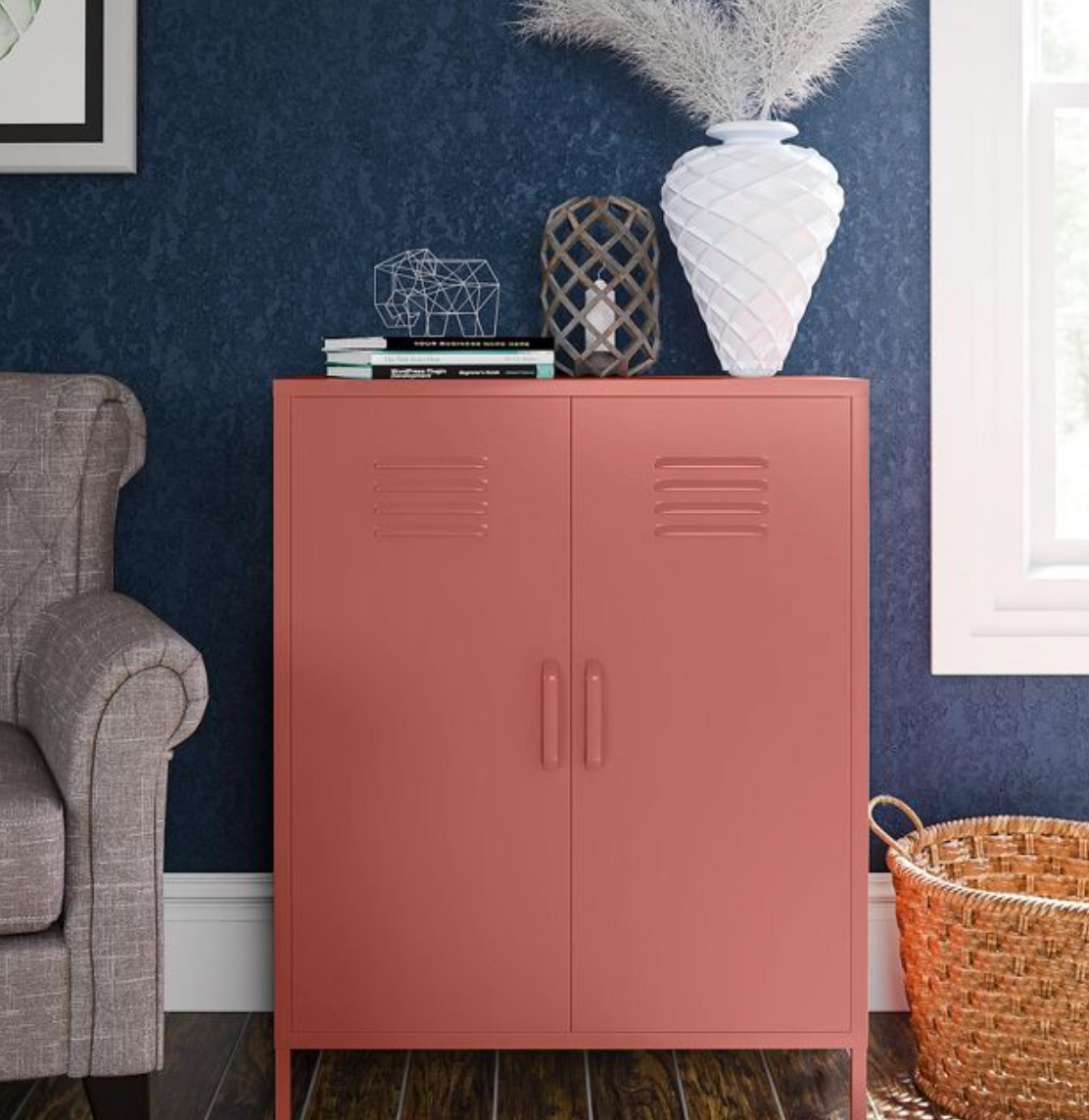 Red metal locker accent cabinet with books and decorations on top