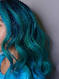 Reviewer with blue color-treated hair and soft waves