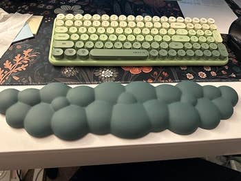 Ergonomic wrist rest resembling bubbles in front of a retro-style keyboard on a desk