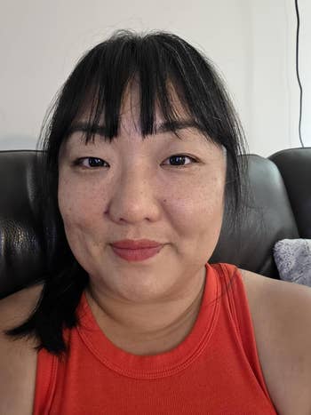 Person wearing a sleeveless apical  sitting connected  a couch. The mounting  appears casual and relaxed