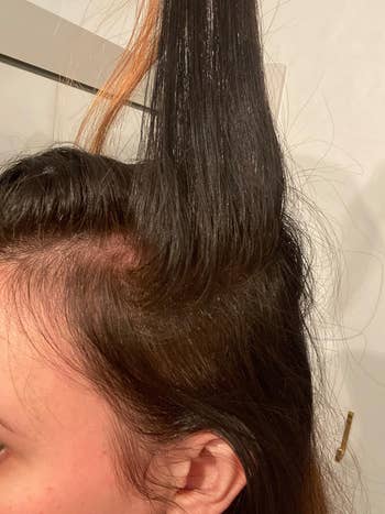 Reviewer showing hair after using root cover-up spray with all the hair being the same color