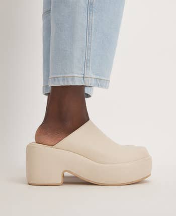 a model wearing the white clogs