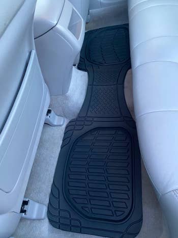 reviewer's long black car mat in the backseat 