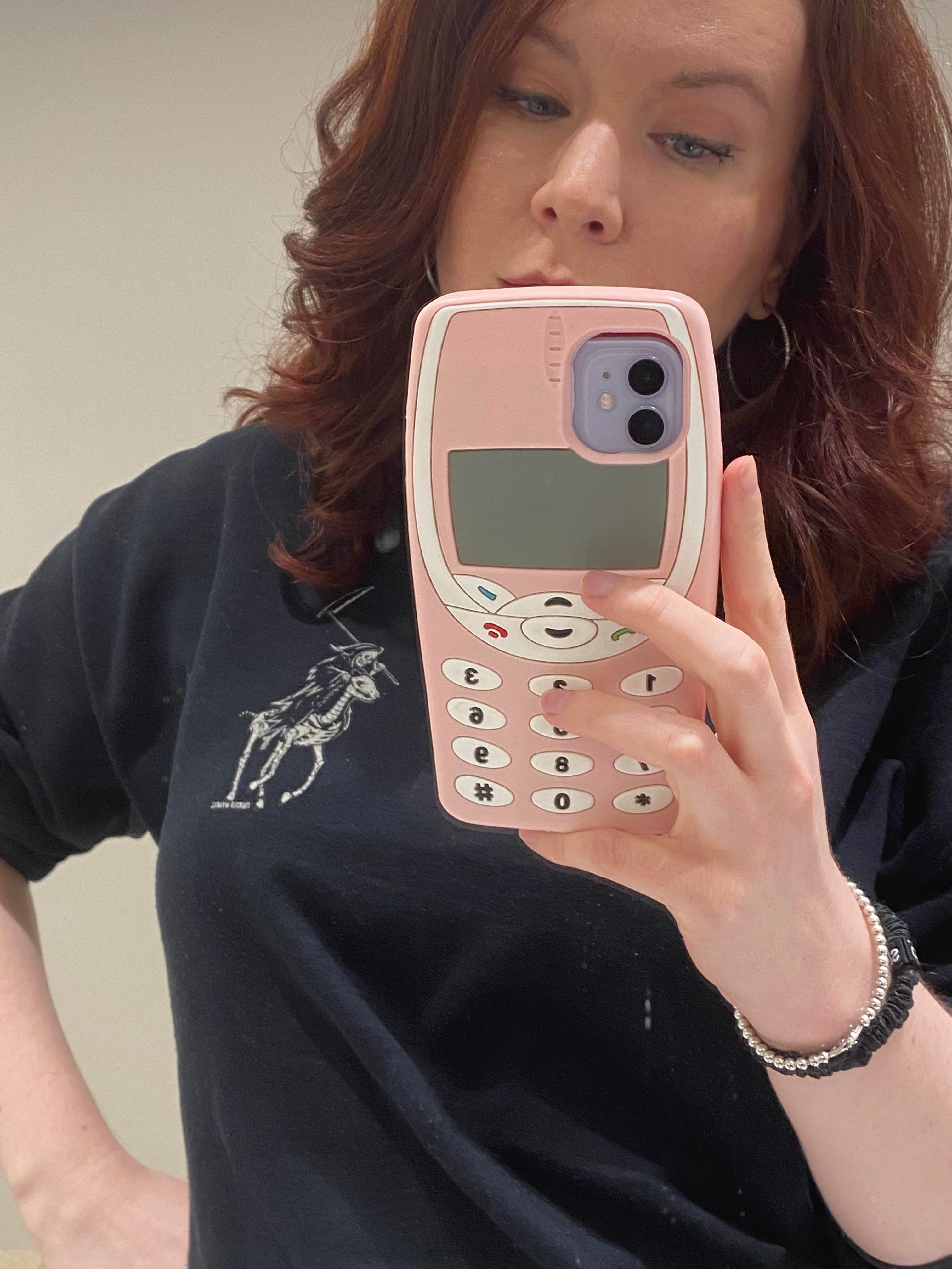 BuzzFeed editor Elizabeth Lilly holds cellphone with pink Nokia-inspired cell phone case covering it