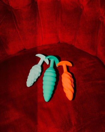 Light blue, green and orange butt plug side by side for size comparison