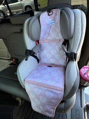 a reviewer's car seat with the pink cooler placed on it