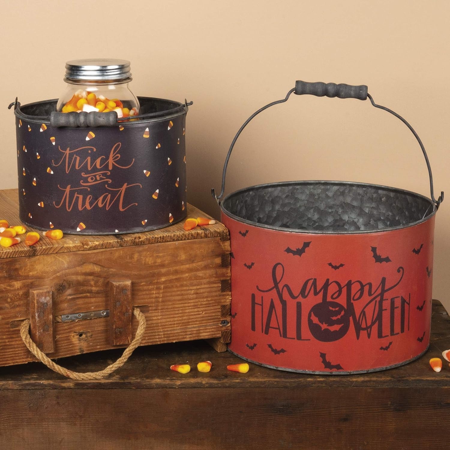 two decorative halloween buckets on wooden table