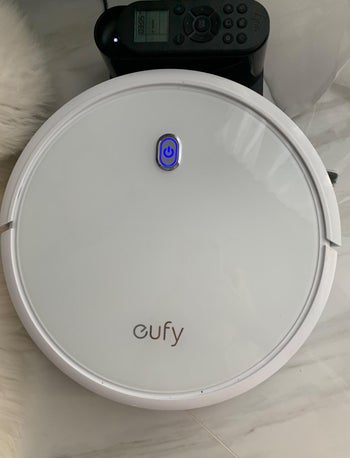 close-up of white robot vacuum on a marble floor