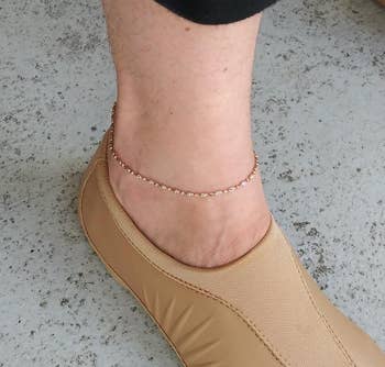 Reviewer wearing the chain ankle bracelet with tan shoes