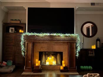 Room with a decorated fireplace, LED candles, and drawstring  lights creating a cozy ambiance
