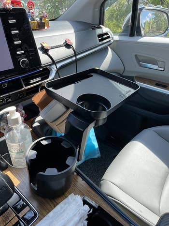 a reviewer with the cupholder expander and tray in their car