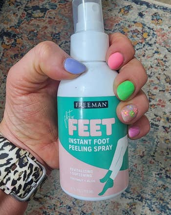 Hand holding Freeman ft peeling spray, showcasing colorful nails