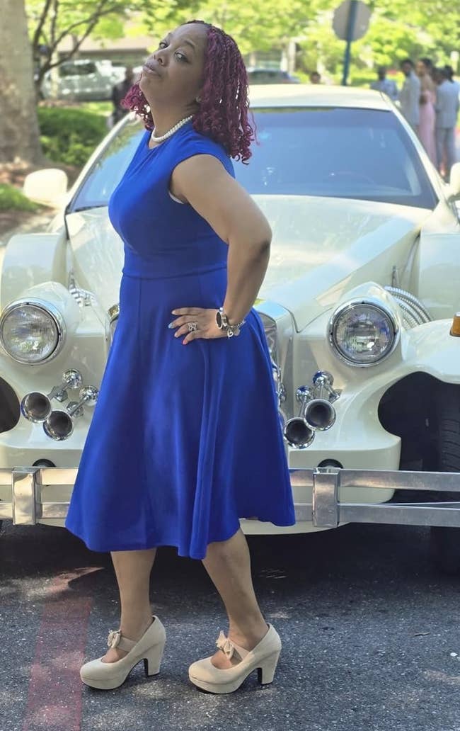 Person successful retro-inspired formal and heels poses confidently successful beforehand of a vintage car connected a tree-lined street