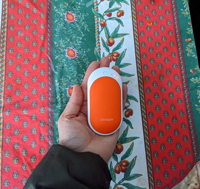 image of reviewer holding an orange hand warmer
