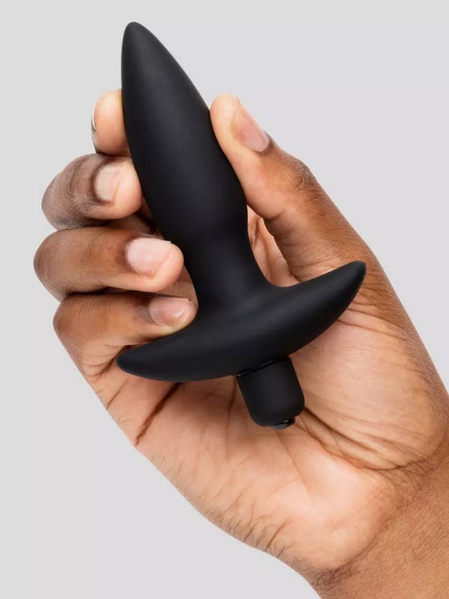 Hand holding black vibrating plug