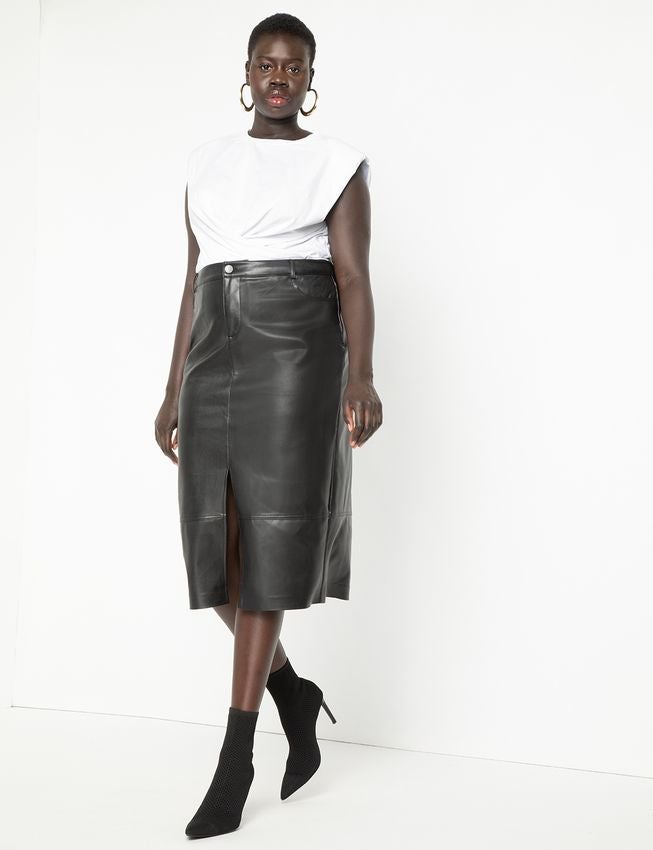 model wearing a white t-shirt tucked into the skirt and black pointed booties