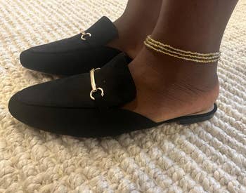a reviewer wearing the same shoes in black with gold-tone horse bit hardware 