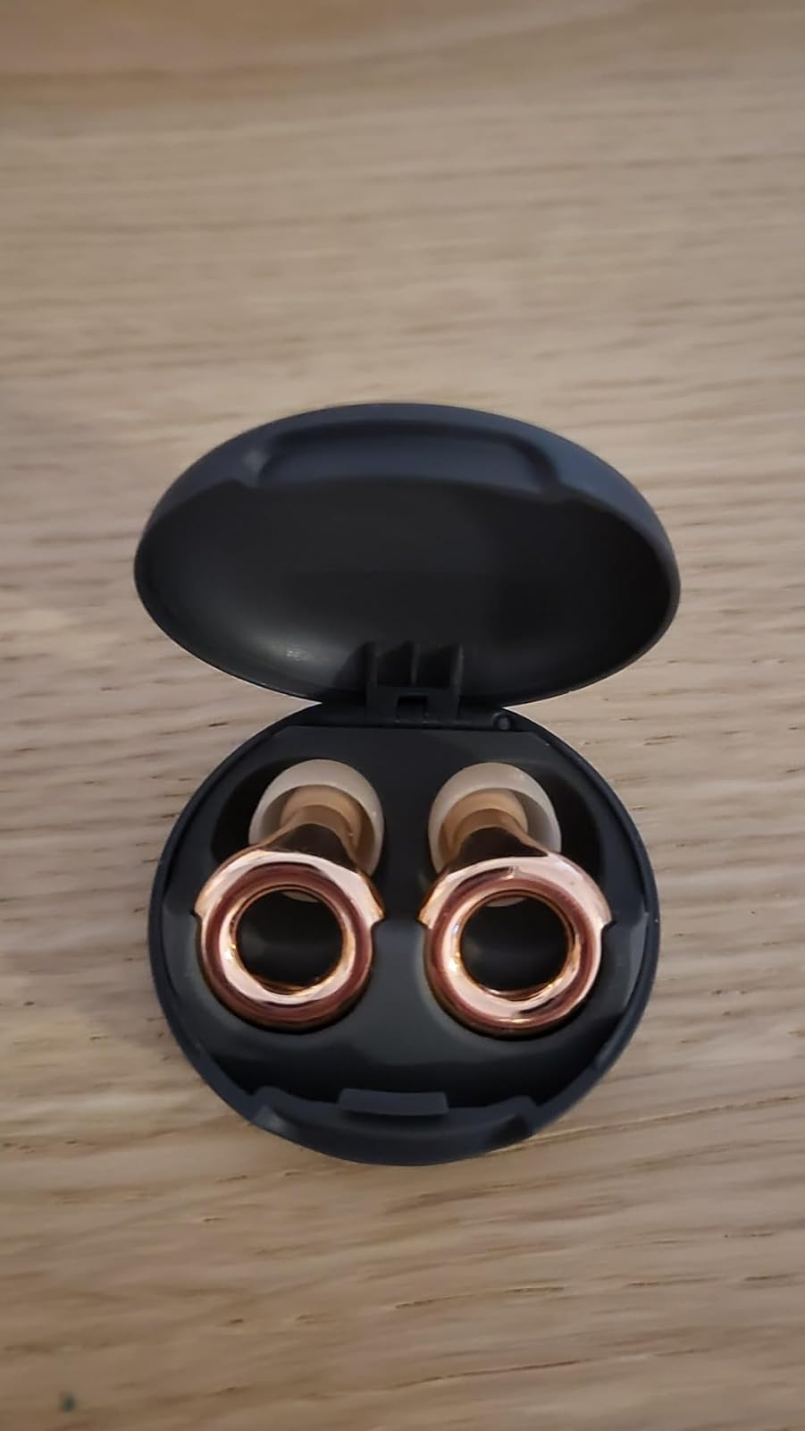 Open achromatic  lawsuit  with a brace  of gold-colored wireless receptor  plugs 