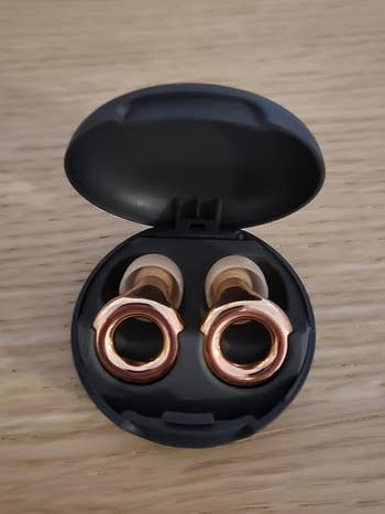 Open achromatic lawsuit with a brace of gold-colored wireless receptor plugs