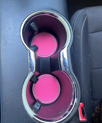Pink car coasters with glitters on the edges in a cup holder 