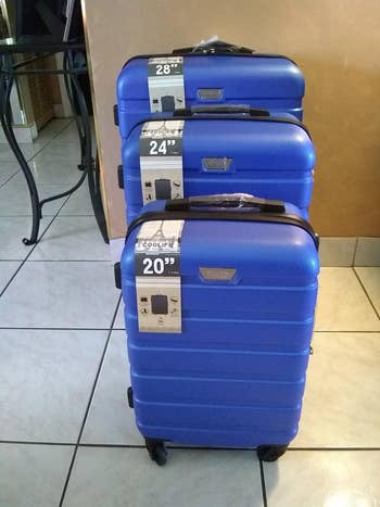 the same three-piece luggage set in a dark blue color