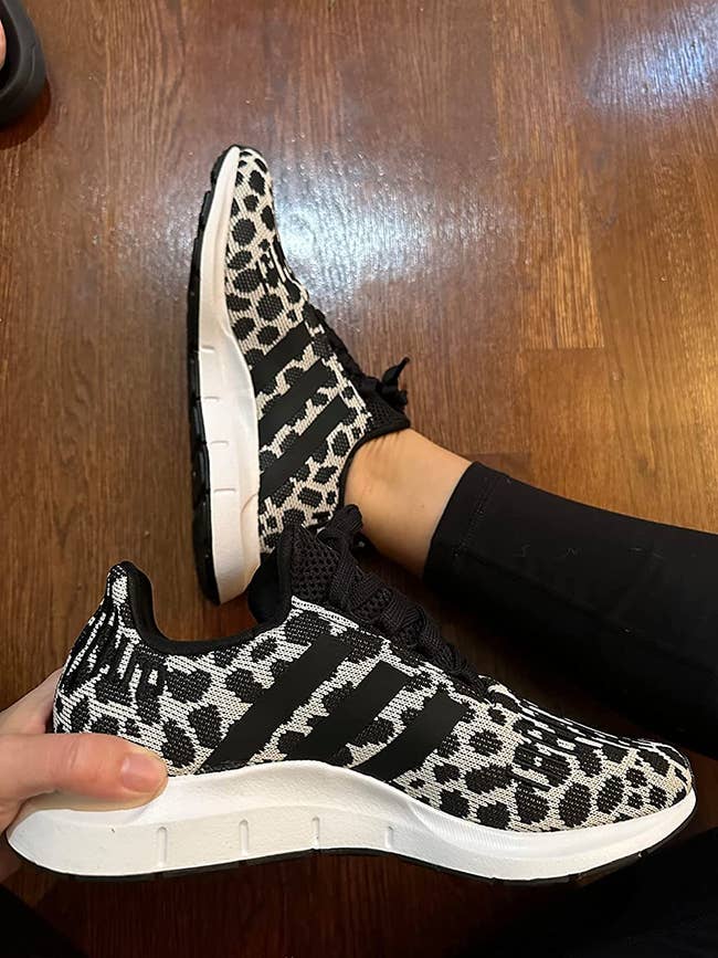 reviewer image of the sneakers with black and white animal print all over them
