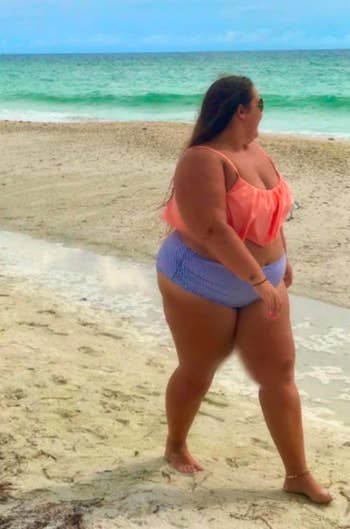 reviewer wearing the bikini with a coral top and striped bottoms